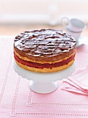 Chocolate pear cake with white and red sponge layer on cake stand