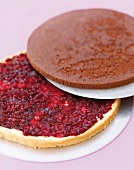 Layers of chocolate pear cake being placed on pear spread