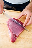 rohes Thunfischfilet, mit Edelstahlesser schneiden