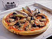 Close-up of clam pizza with black olives on baking tray 