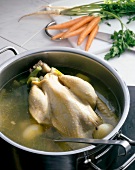 Poularde being cooked with vegetables in pot