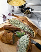 Close-up of sliced stuffed duck with chard on tray with knife