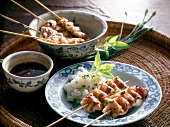 Chicken and bacon skewers with rice and chives on plate