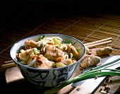 Bowl of marinated chicken with peanuts and spring onions