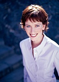 Portrait of pretty woman with brown short hair wearing purple shirt, smiling