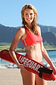 Portrait of happy woman in red bikini enjoying on beach, laughing