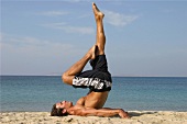 Man doing stretching exercise on the beach