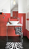 Waschbecken, Spiegel vor rotkarierte r Wand, schwarzkarierter Fußboden
