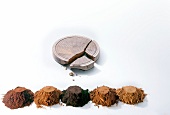 Several types of cocoa powder with cocoa press cake on white background