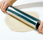 Close-up of marzipan being rolled out thin with rolling pin