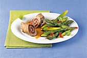 Pork roulade with green asparagus on plate