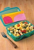 Potato salad with chicken and tomatoes in blue tiffin box