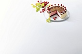 Raspberry cream cake with fresh raspberries on plate against white background