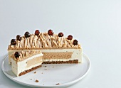 Half chestnut cream cake with cherries on plate0