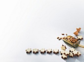 Star shaped chocolates with almonds in scoop on white background