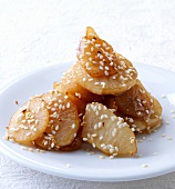 Radish and fried nashi pears in sesame seeds on plate