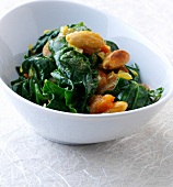 Root spinach with almonds, garlic and tomato in bowl