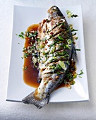 Crispy trout with chilli honey sauce and spring onions on plate