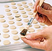 Close-up of chocolate being spread on marzipan circles, step 2