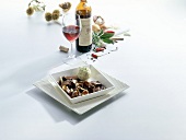 Wild hare in chocolate sauce on plate with wine and spices