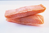 Close-up of two frozen pollock fillets on white background