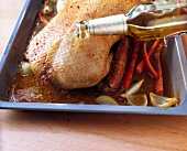 Basting duck with beer in baking dish, step 1