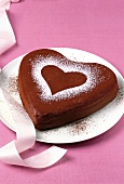Backen, Schokoladenkuchen in Herzform mit Herz aus Puderzucker