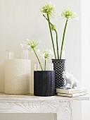 Three vases with homemade knitted covers on a side table