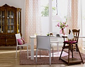 Dining room with table, curtains, white chairs and baroque cabinet