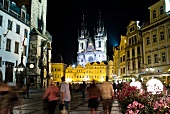 Prags Altstadt bei Nacht, beleuchtet Menschen auf dem Platz, unscharf