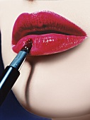 Frau bemalt mit Pinsel Lippen rot close - up
