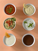 Six bowls with different types of sauces