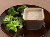 Broccoli on plate with gorgonzola and walnut sauce in bowl