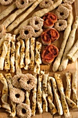 Sesame rings, cheese sticks, herb grissini on wooden surface