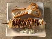 Meat skewer and bread on plate