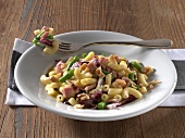 Ham, green beans and walnuts in dish on wooden table