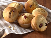 Six cranberry muffins on striped table cloth