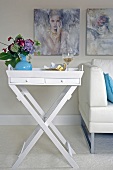 Close-up of white foldable side table with vase and wine glass