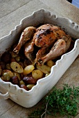 Roasted chicken with potatoes, olives and herbs in casserole dish