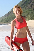 Portrait of happy woman in red bikini enjoying on beach, laughing