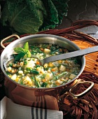Vegetable soup in copper pot with ladle
