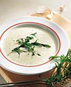 Creamy arugula soup with garlic on plate