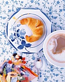 Backen, Croissant mit Fruchtmarzipan und Tasse Milchkaffee