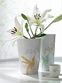 weiße Blumen in weißen Porzellanvasen mit Kolibris verziert