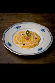 Risotto with yellow pumpkin, amoretti and goat gorgonzola sauce on plate