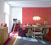 Striped carpet on stairs with dining table against red wall