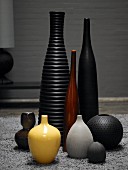Stillleben aus verschiedengrossen Vasen in verschiedenen Farben auf Tepppich
