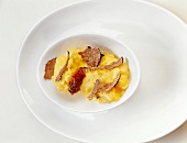 Scrambled eggs with truffles on serving dish, overhead view