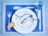 Plate with round menu card, fish, note and slice of bread