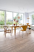 Dining table and chairs in front of windows